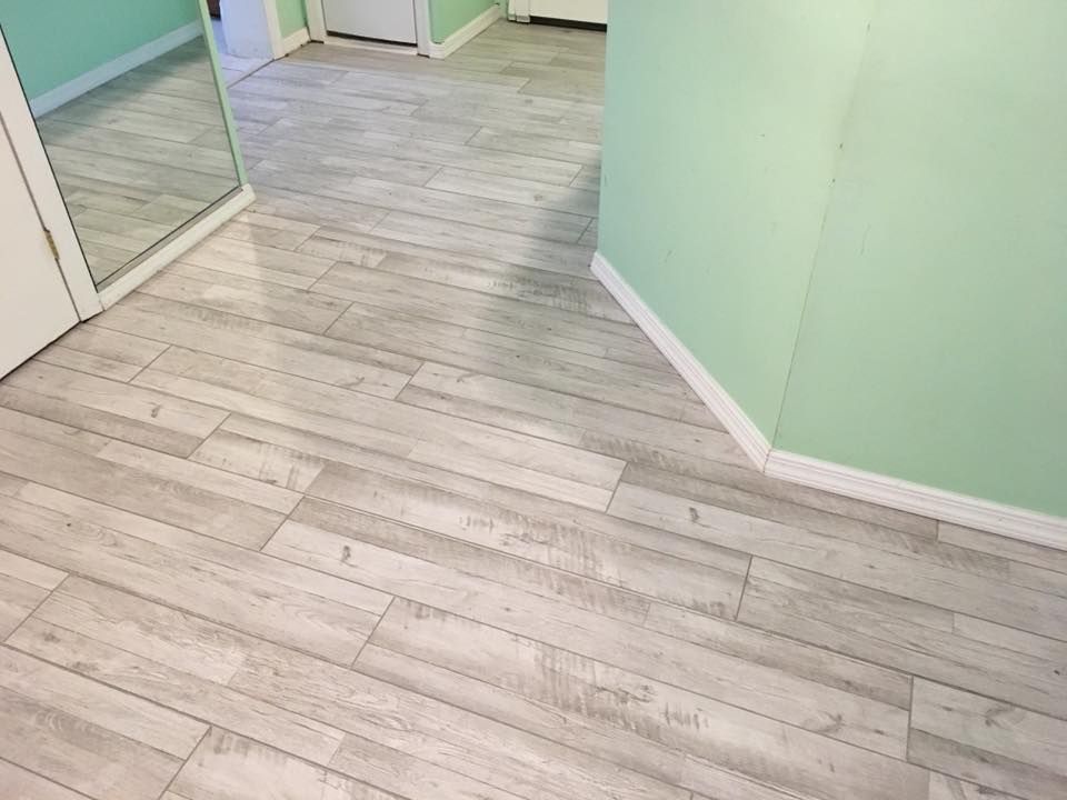 Empty room with light wood flooring, mint green walls, and mirrored closet doors