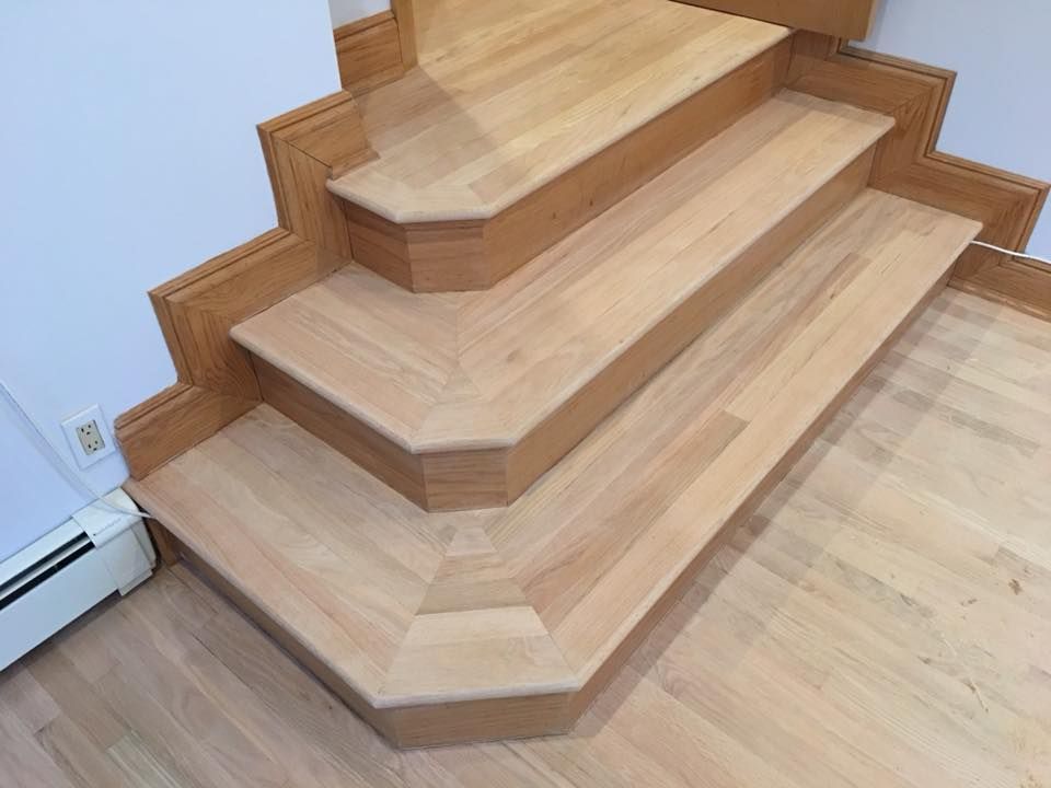 Wooden staircase corner with light wood steps and trim in a home interior