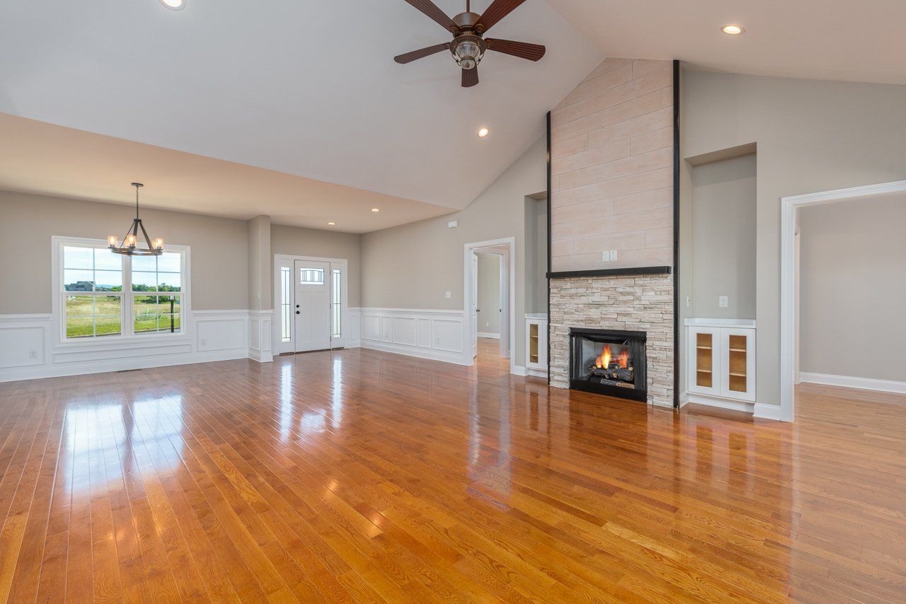 Spacious living room with hardwood floors, fireplace, and large windows with a view.