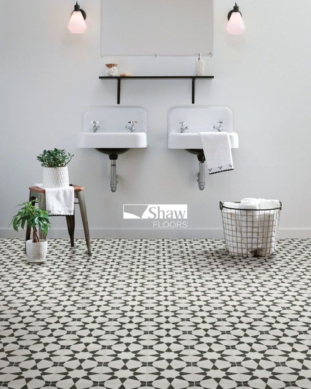 A bathroom with two sinks and a basket on the floor