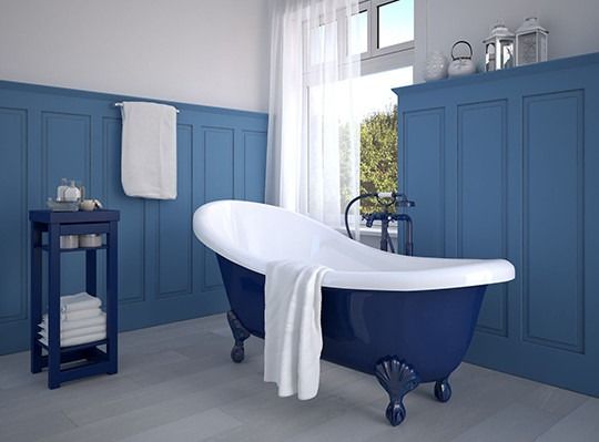 A bathroom with blue walls and a blue bathtub.