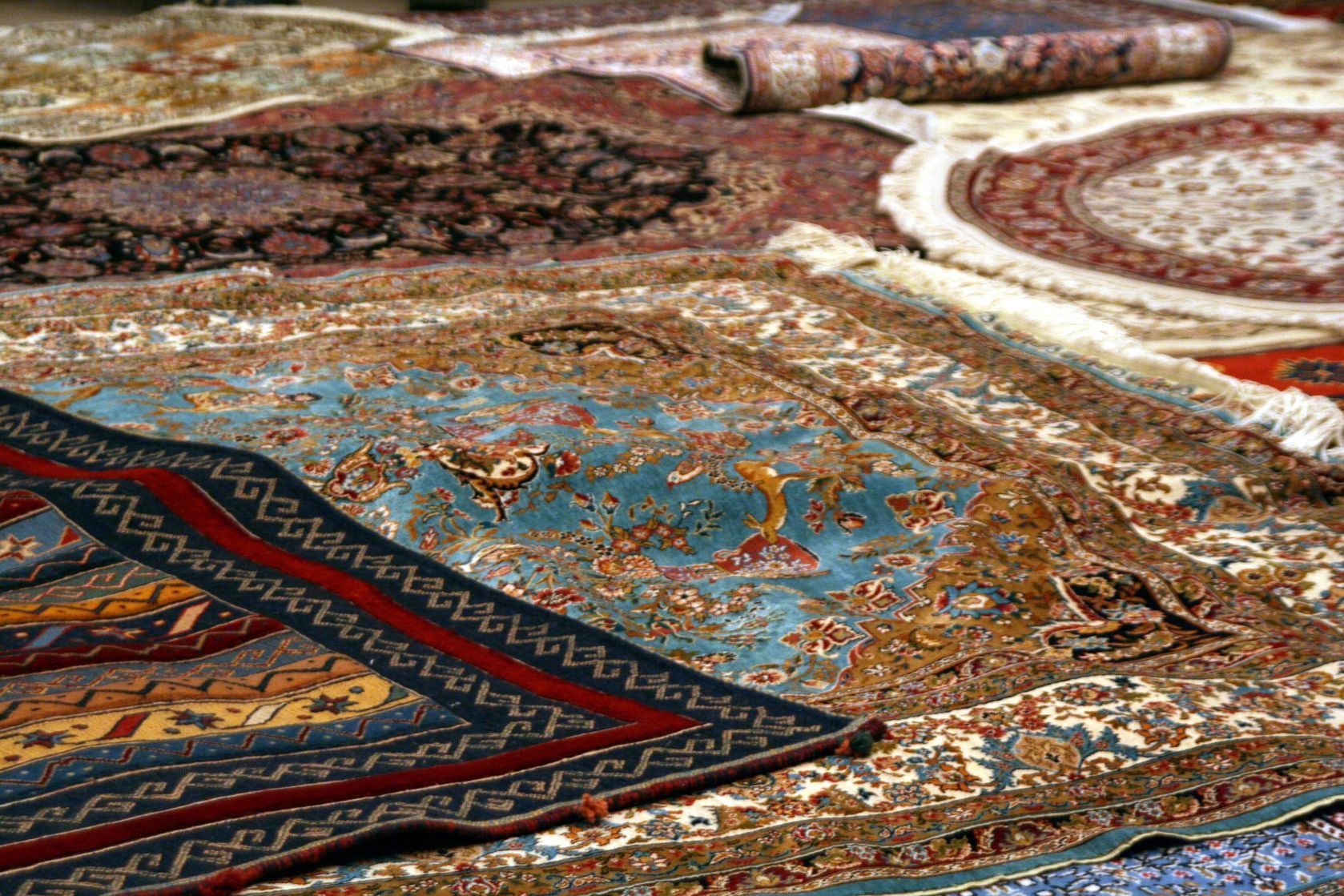 A bunch of rugs are stacked on top of each other on a table.