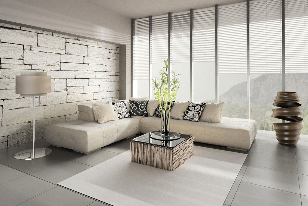 Living room with beige sectional sofa, stone wall, and large windows with blinds. Glass coffee table and floor lamp.