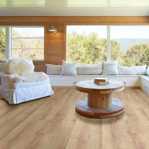 A living room with hardwood floors , a chair , a table and a window seat.