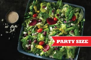 A salad with lettuce , tomatoes , olives and feta cheese on a plate.