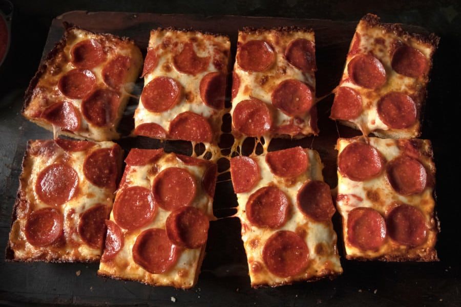 A tray of pepperoni pizza slices on a table.