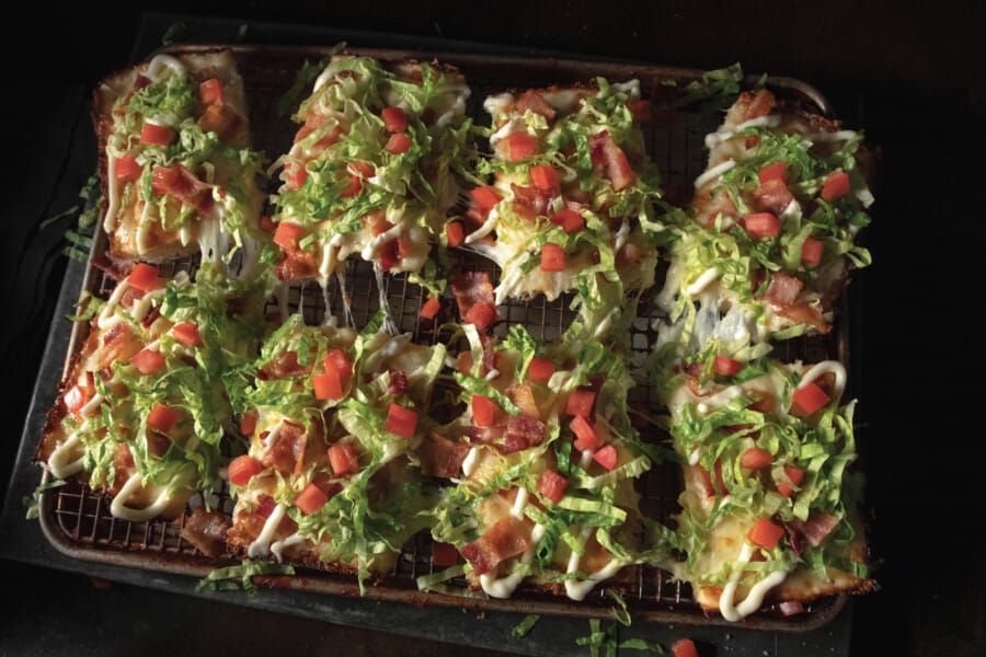 A tray of food with lettuce , tomatoes and cheese on it