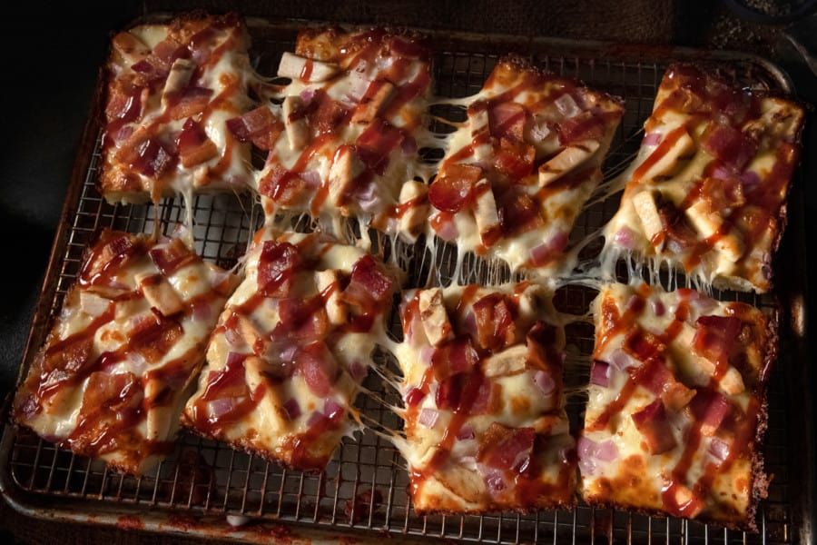 A bunch of pizza slices are sitting on a wire rack.