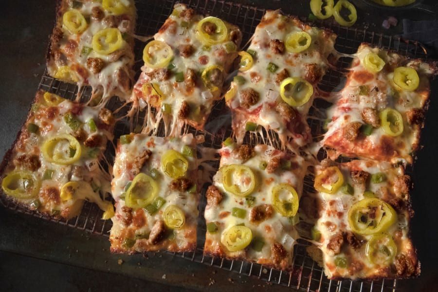 A bunch of pizza slices are sitting on a wire rack.