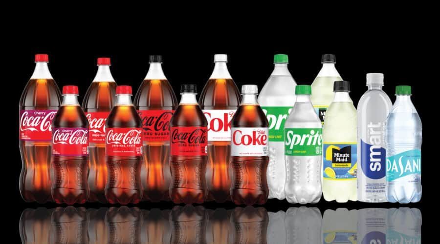 A row of soda bottles including coca cola , diet coke , sprite and smart water.
