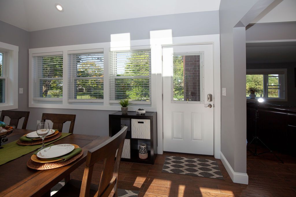 A dining room with a table and chairs and a white door