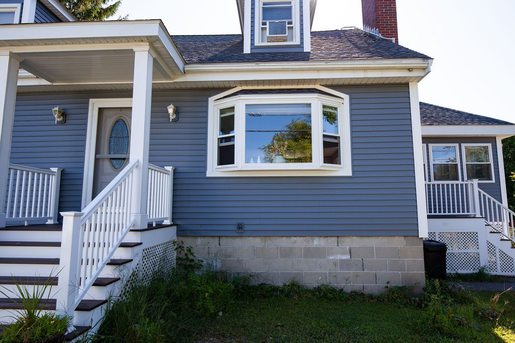 A blue house with a white porch and stairs