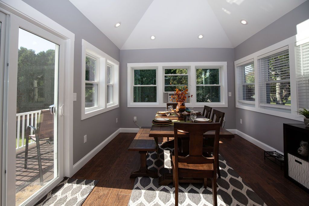 A dining room with a table and chairs and sliding glass doors