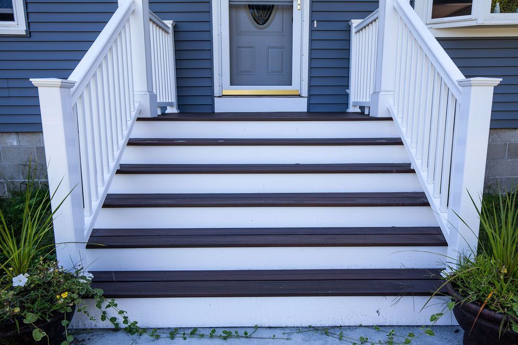 A blue house with white stairs leading up to the front door.
