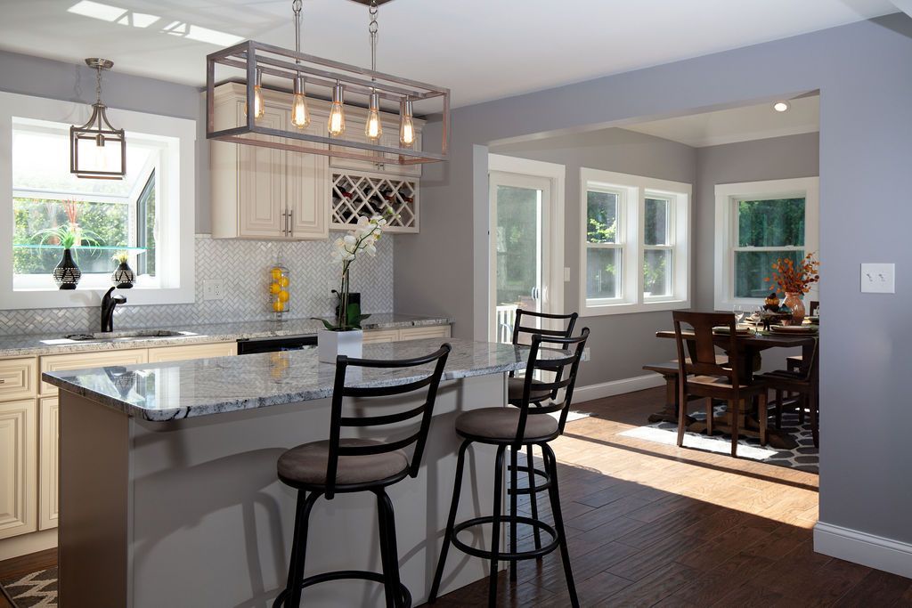 A kitchen with a large island and two bar stools.