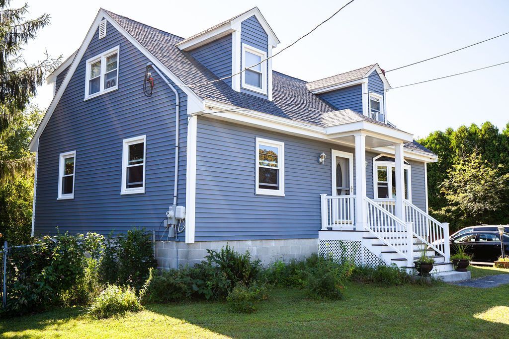 A blue house with a white porch and stairs