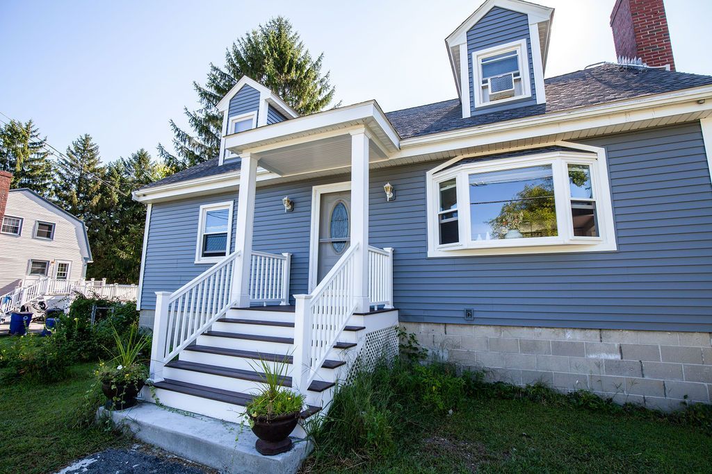 A blue house with a white porch and stairs
