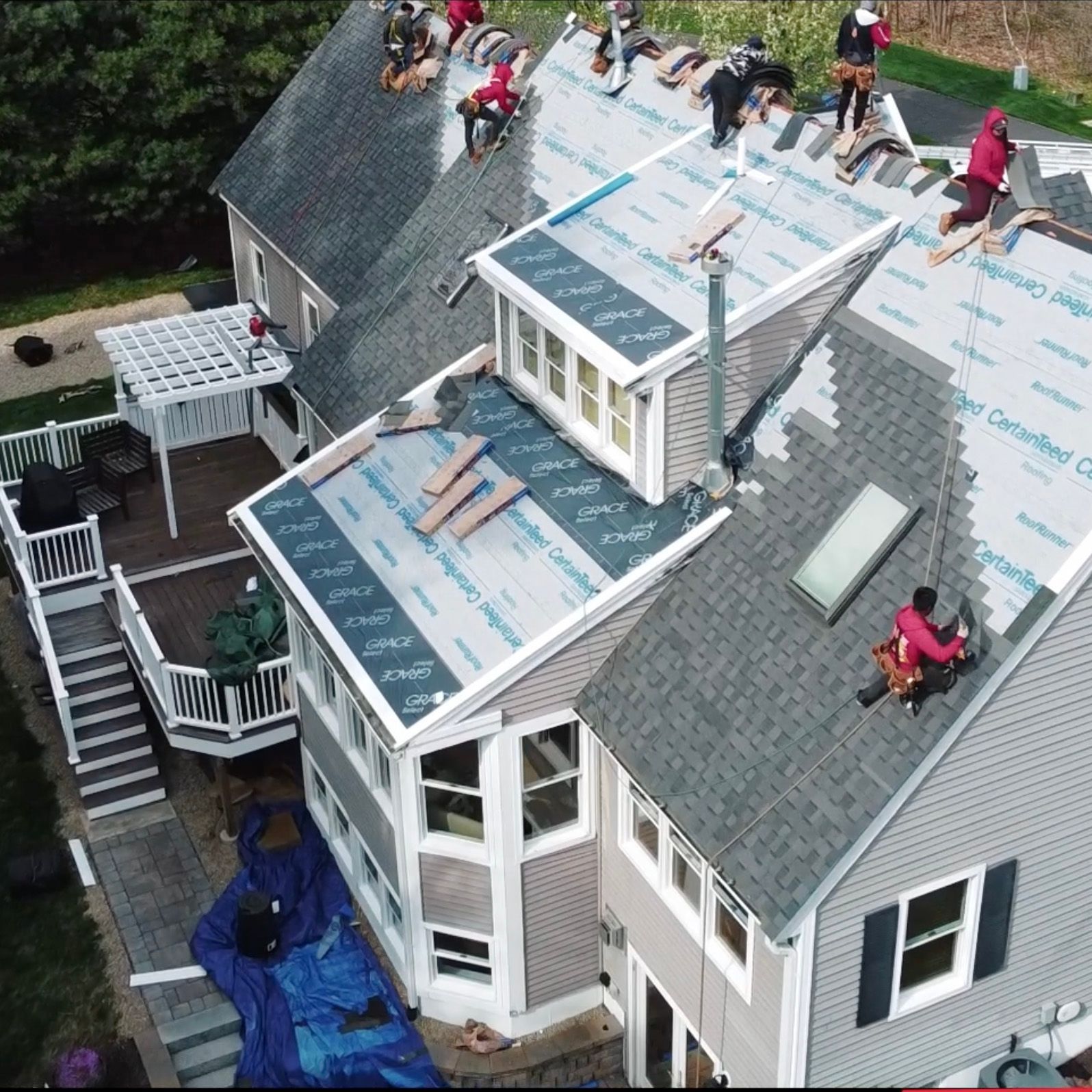 A group of people are working on the roof of a house