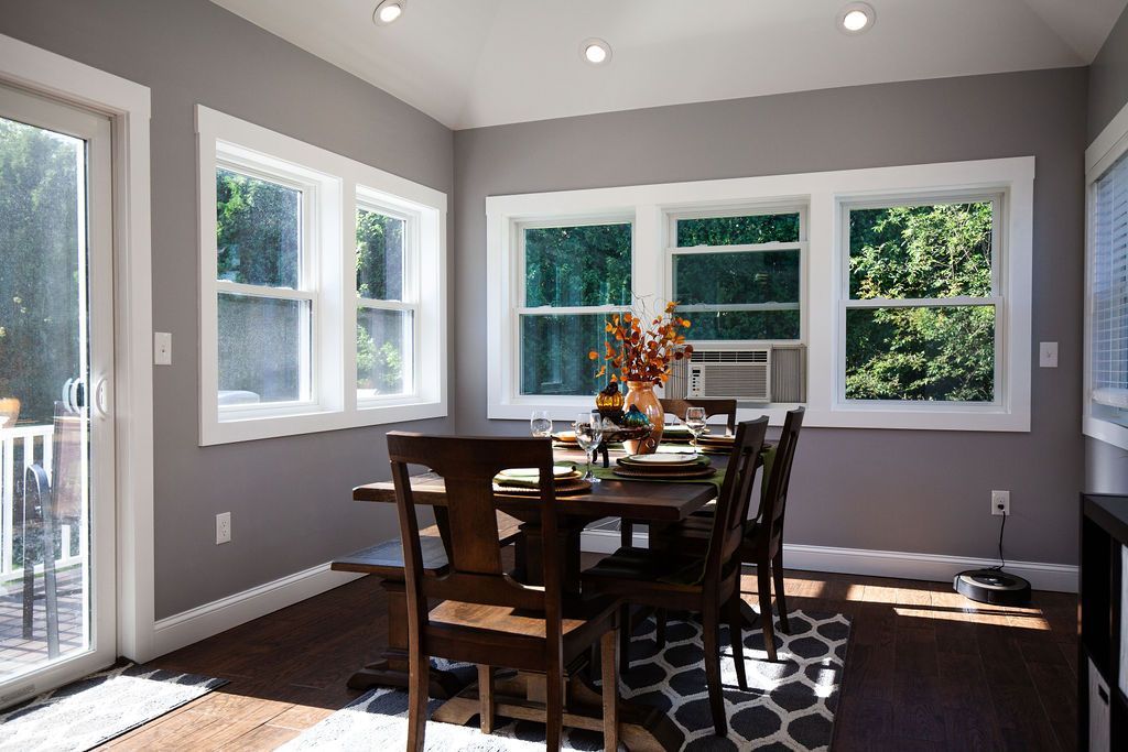 A dining room with a table and chairs and a sliding glass door