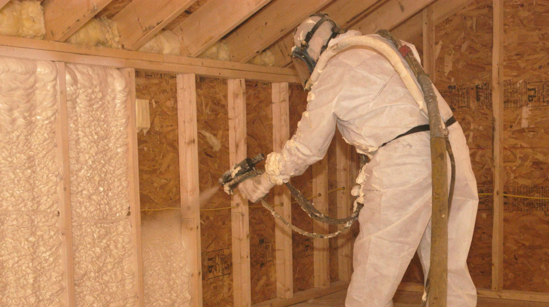 A stack of drywall is sitting in a garage under construction.