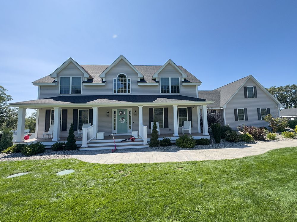 A large house with a large porch and a large lawn in front of it
