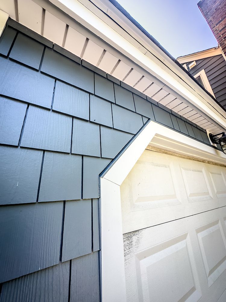 A white garage door with a gray shingle roof