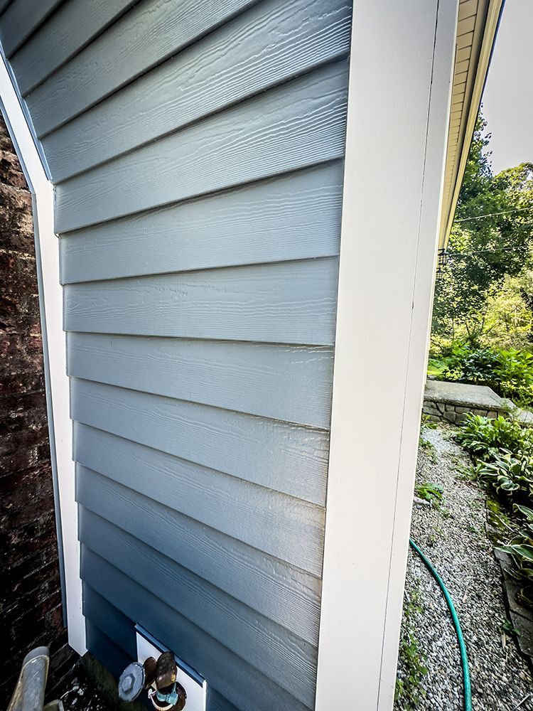 The side of a house with a hose attached to it.