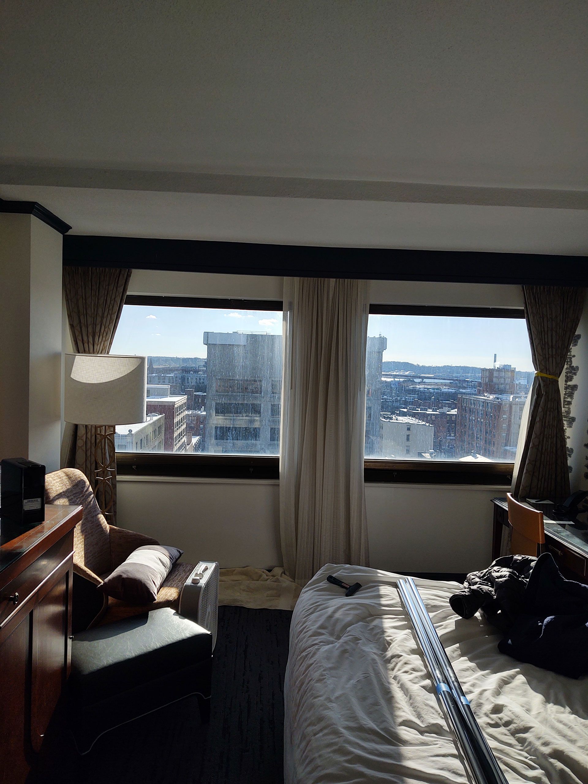 A hotel room with a large bed and a large window
