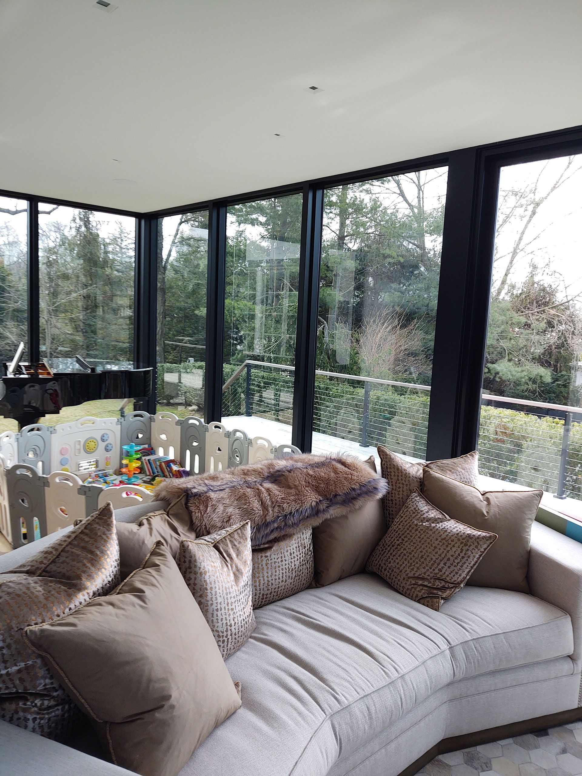 A living room with a curved couch and lots of windows