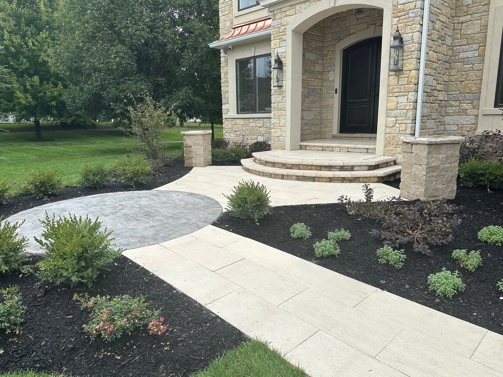 A stone house with a walkway leading to the front door.