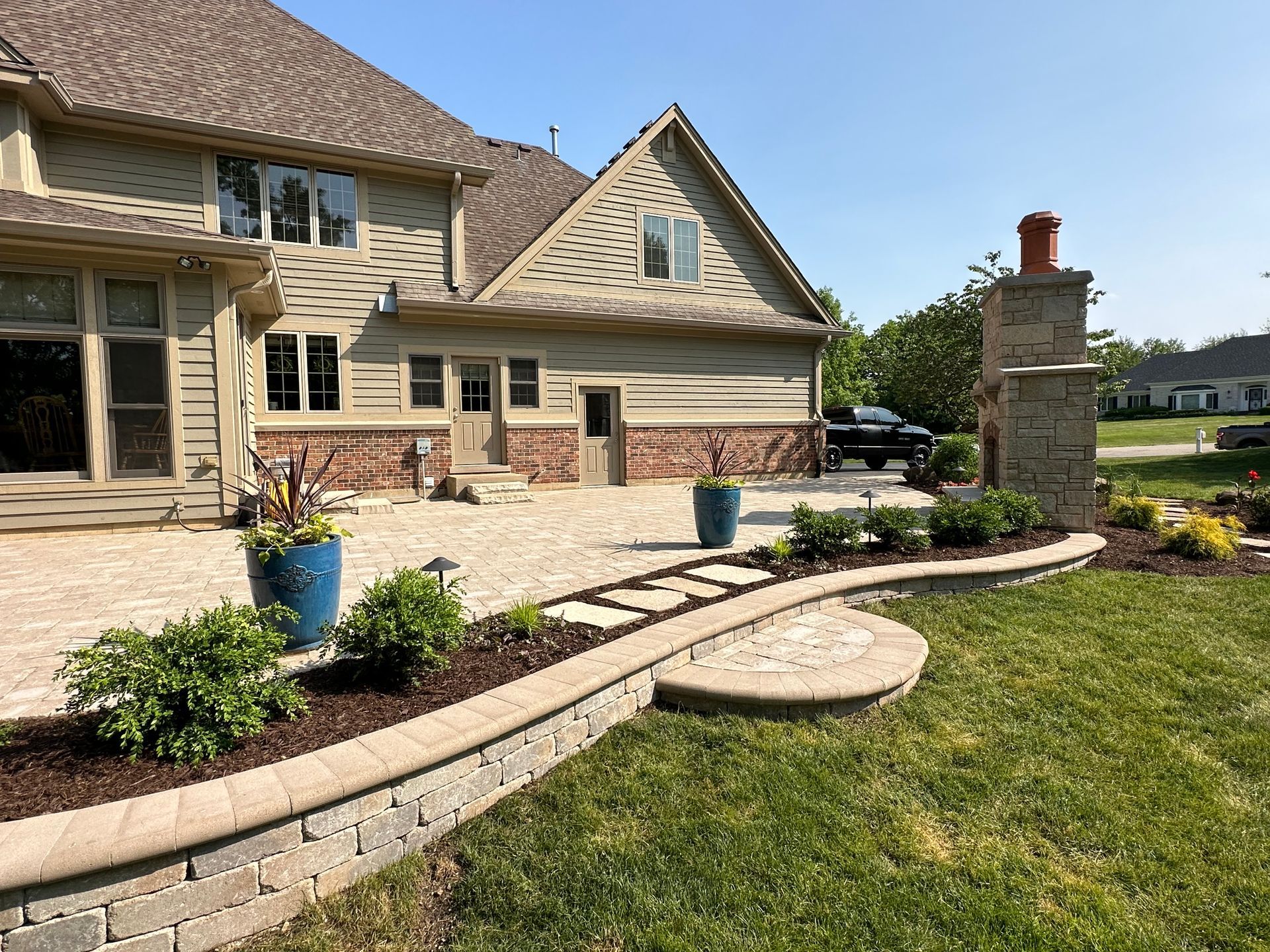 A large house with a patio and a fireplace in the backyard.