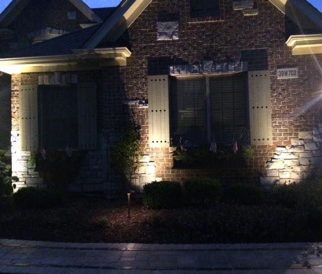 The front of a brick house with a sign that says ' the garage ' on it
