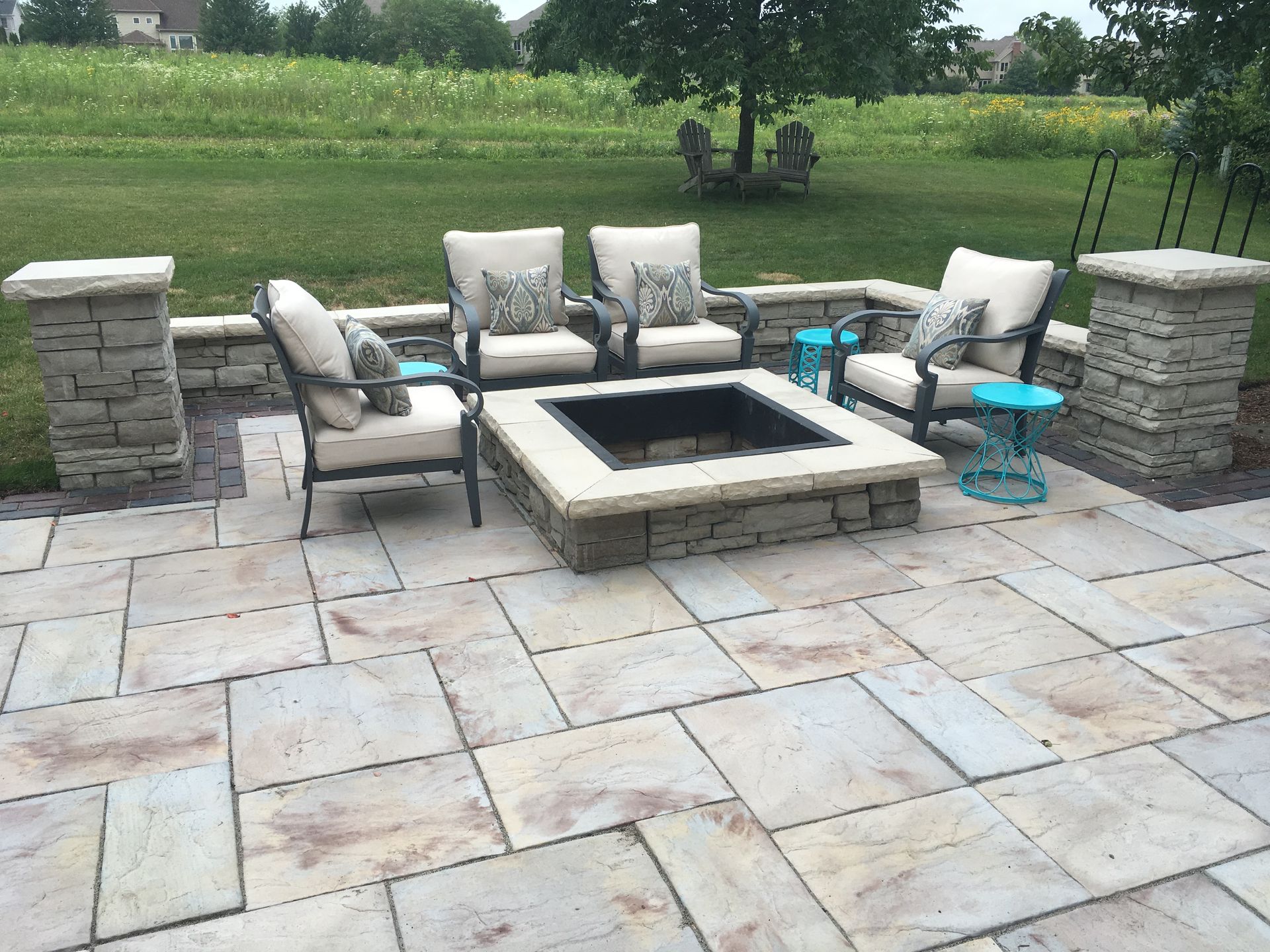 A patio with a fire pit and chairs on it