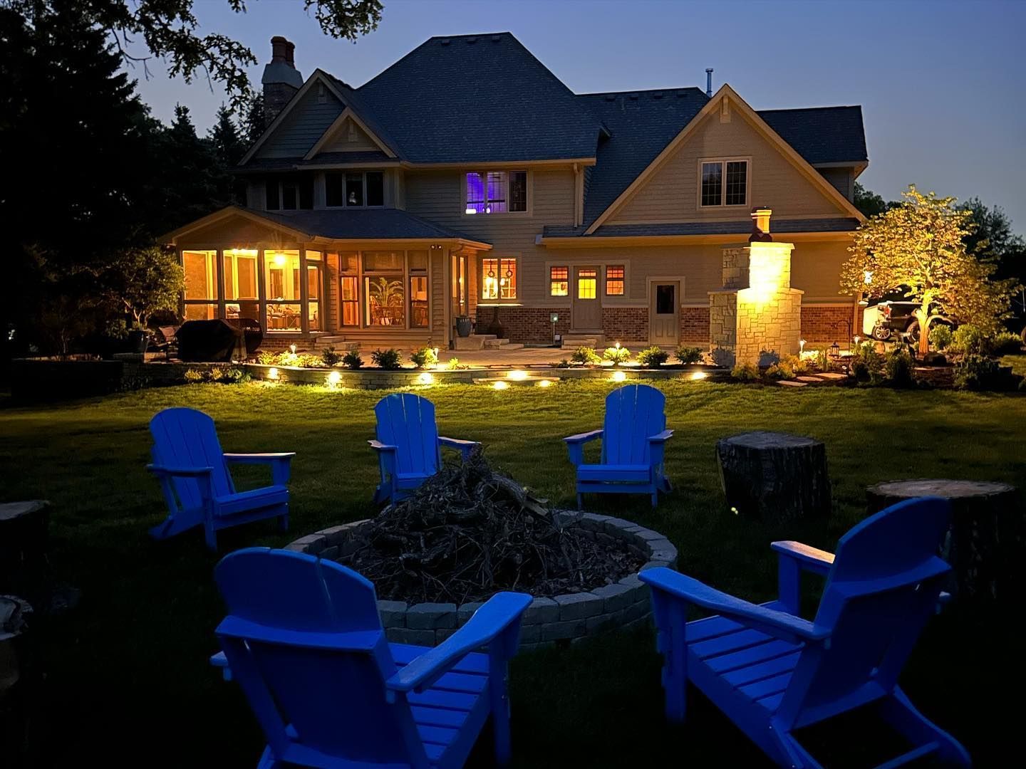 A house with a fire pit in front of it at night