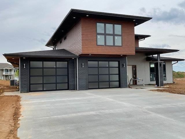 A house with two garage doors and a concrete driveway