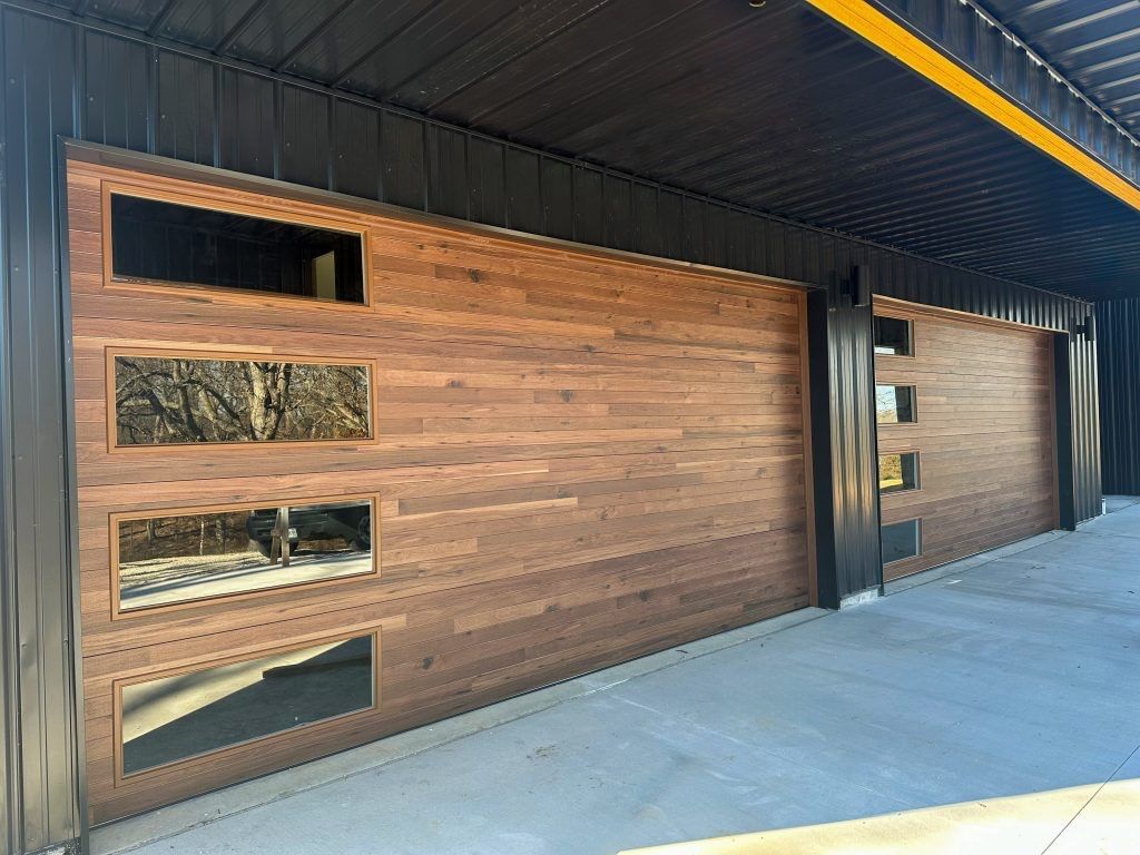 A wooden garage door with a black roof