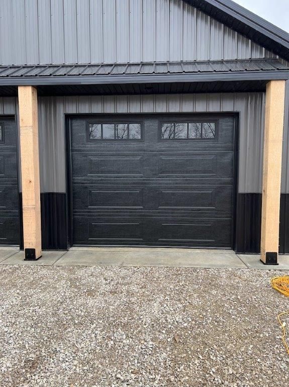 A metal garage with a black garage door