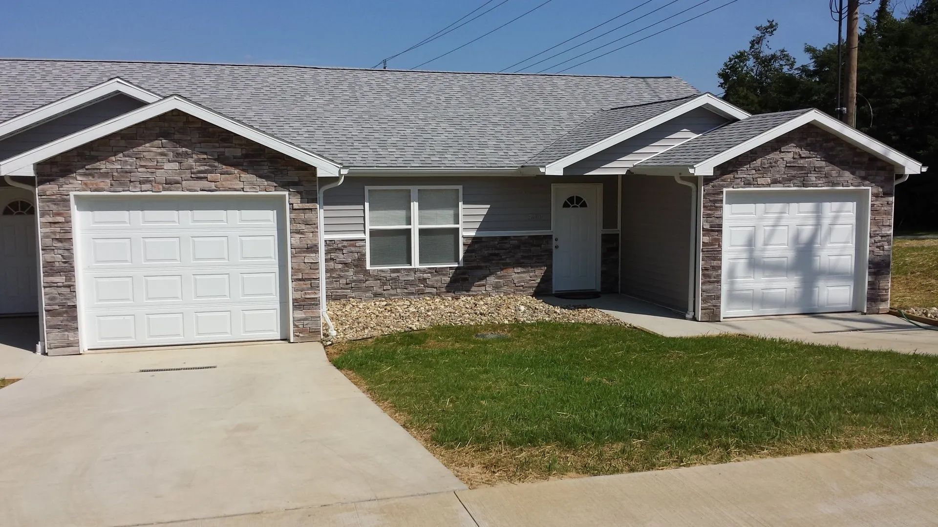 A house with two garages and a lawn in front of it