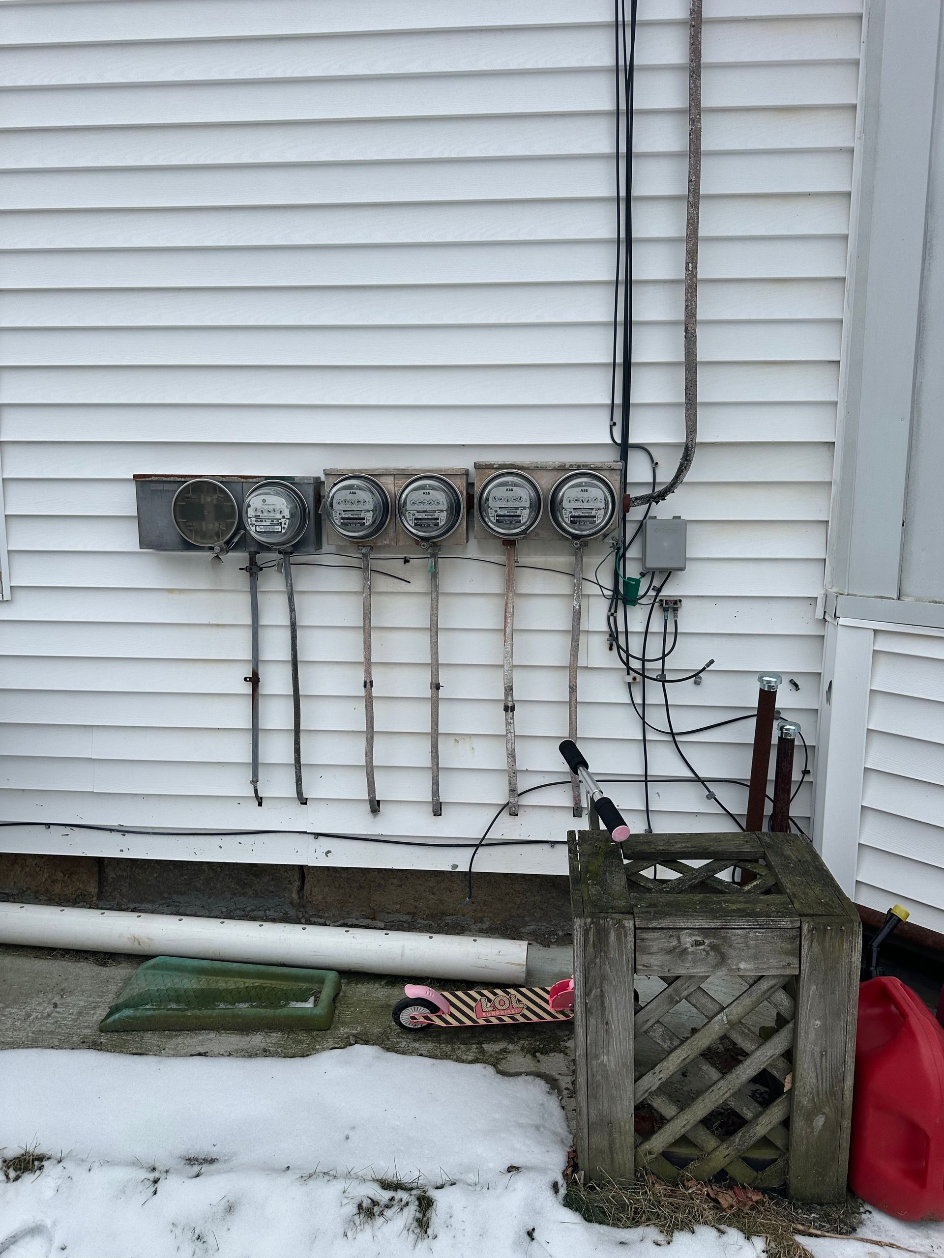 A white house with a lot of electrical outlets on the side of it.