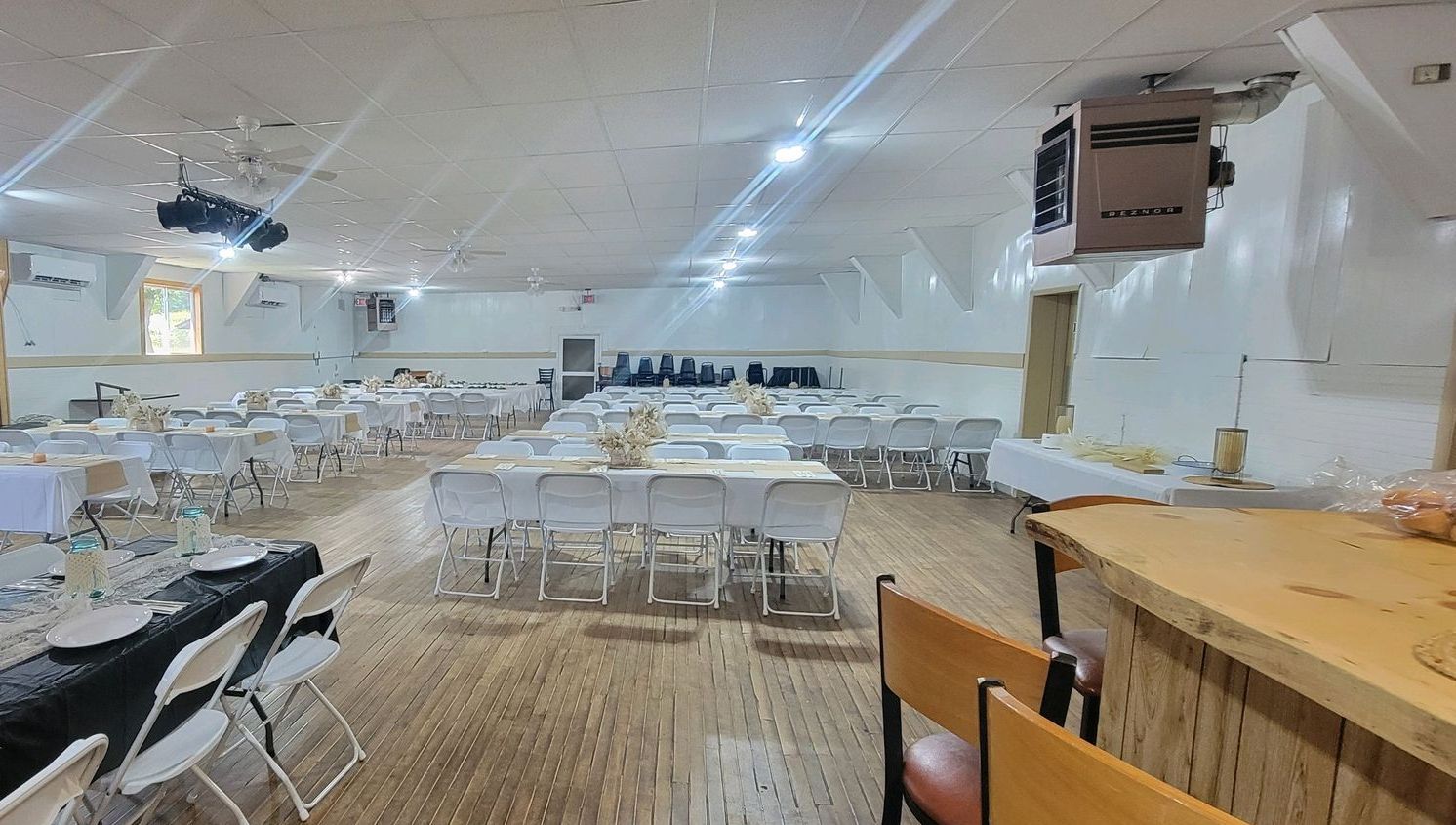 A large room filled with tables and chairs and a bar.