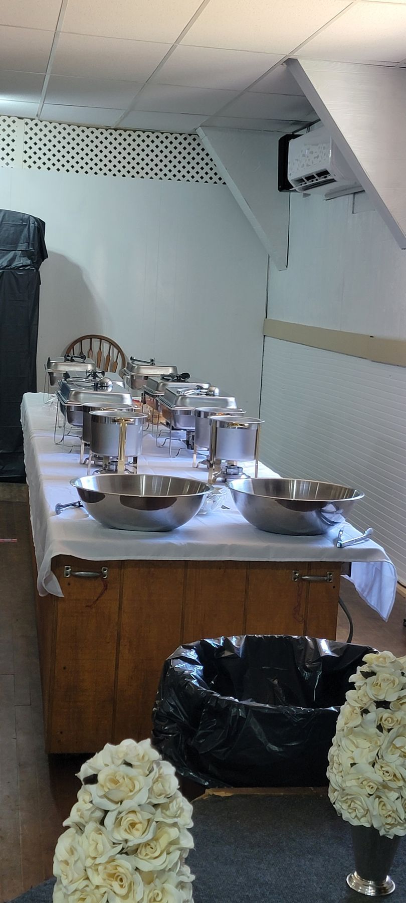 A long table with bowls and pots on it in a room.