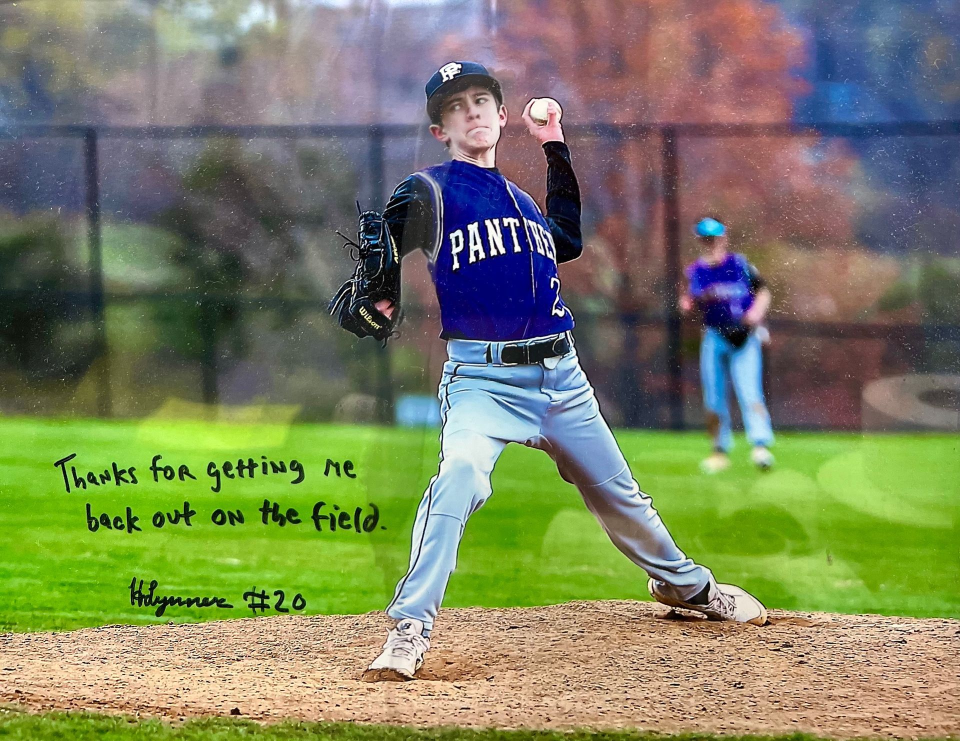 A baseball pitcher in a purple uniform is getting ready to throw the ball