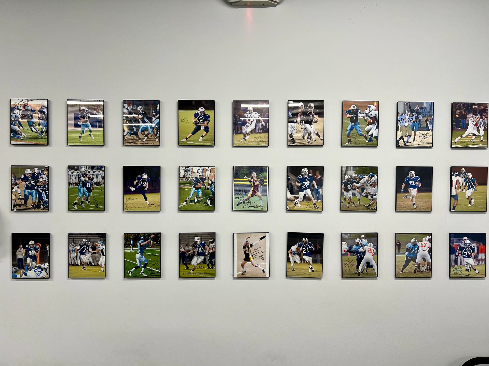 A wall with a lot of pictures of football players on it