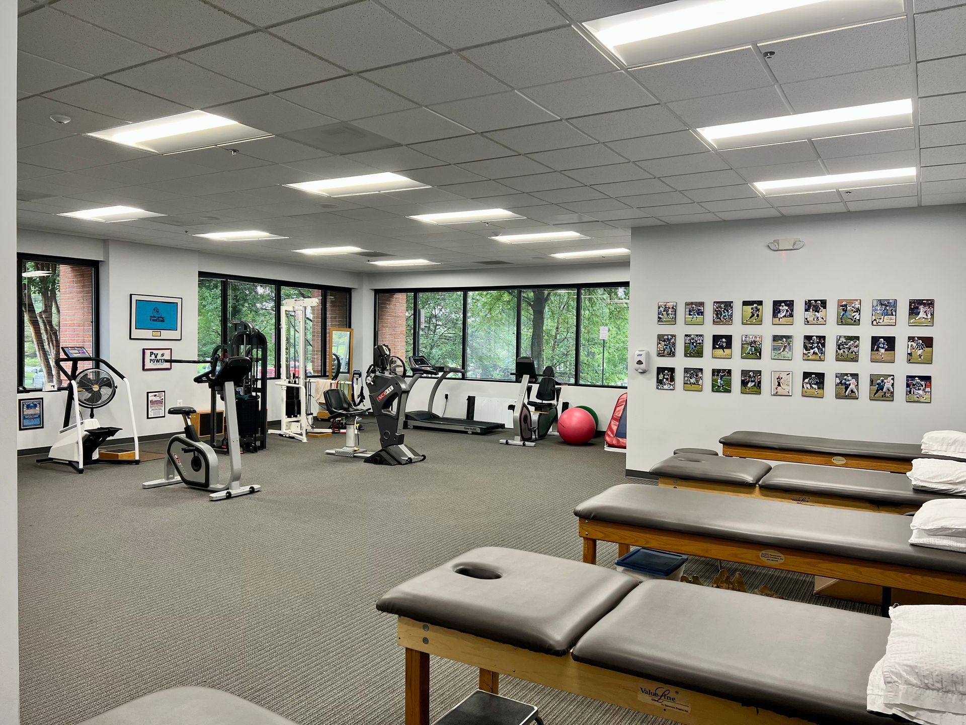A large gym with a lot of exercise equipment and tables.