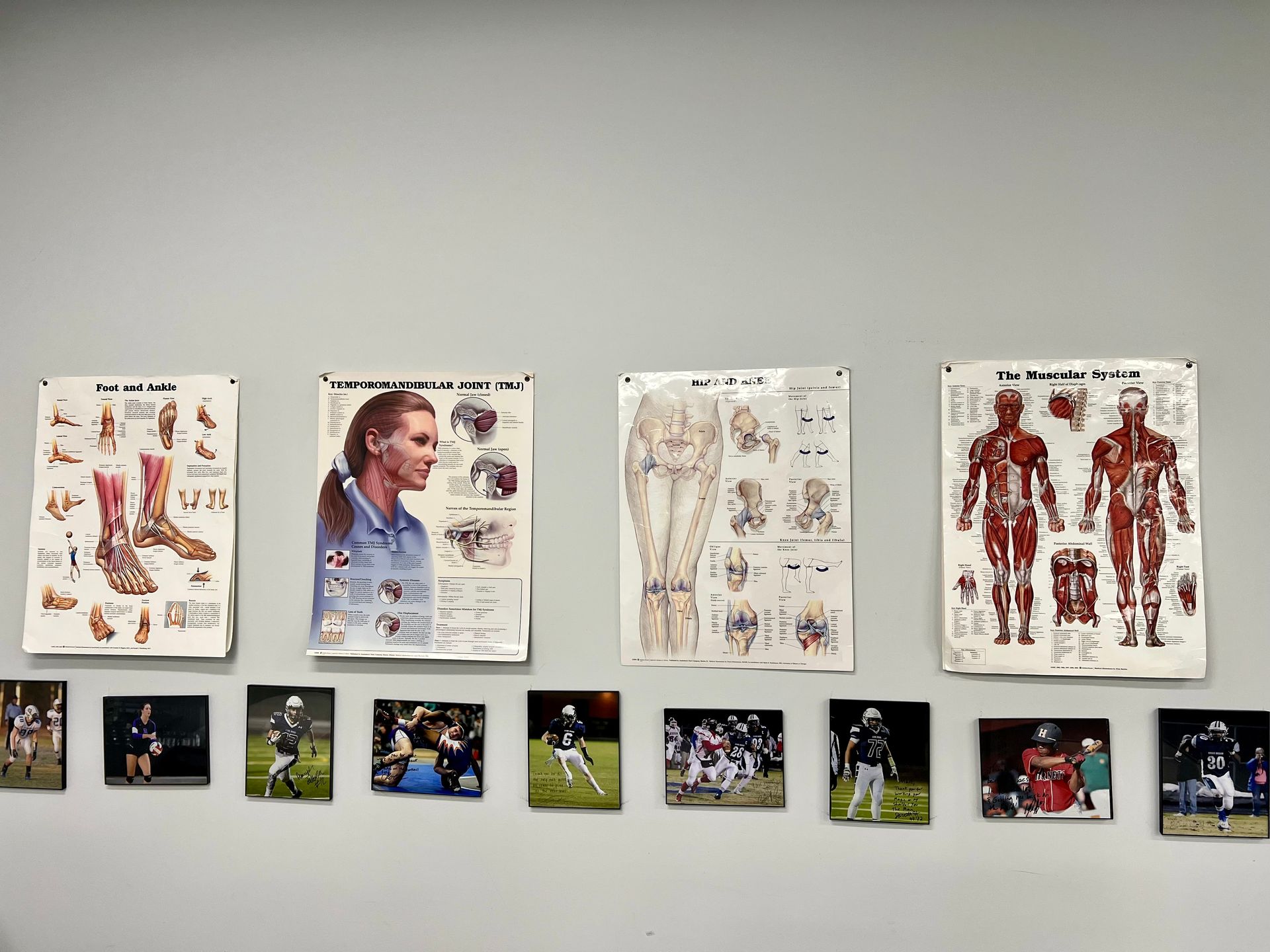 A wall with a bunch of pictures on it and posters on it.