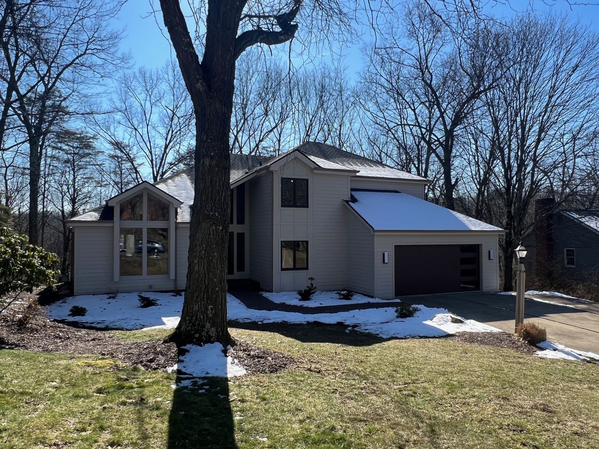 a house with a garage and a tree in front of it