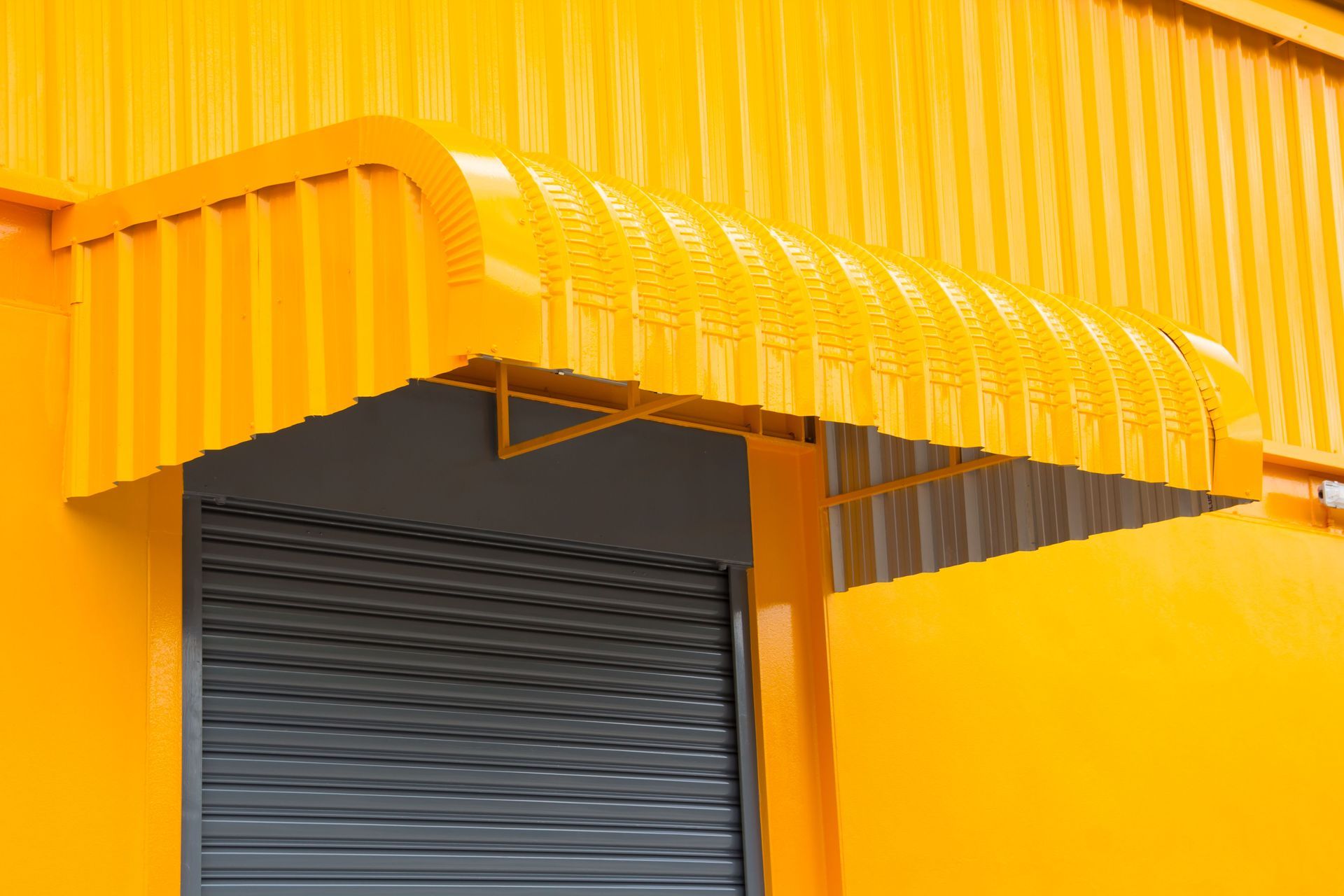 Yellow awning over a gray closed industrial door.