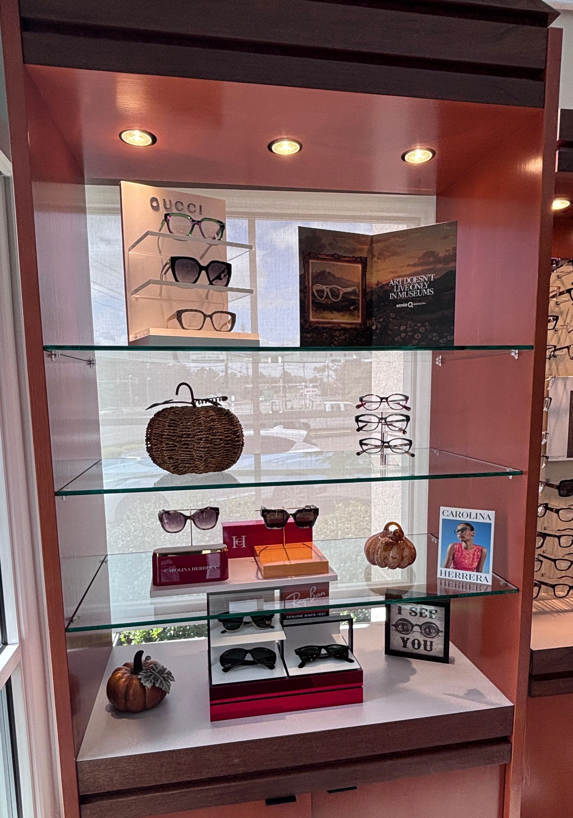 Glass display cabinet with small decorative items and jewelry on lit shelves