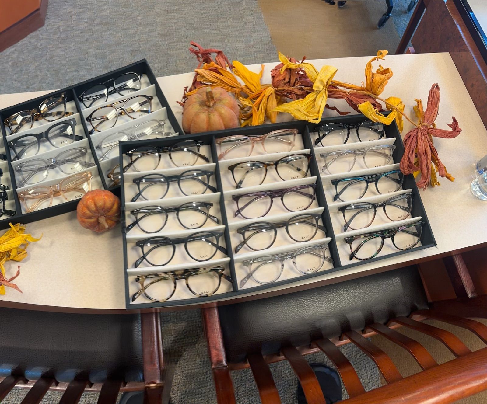 Tray of glasses and autumn decorations on a table with pumpkins and orange leaves