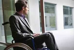 Man on wheelchair looking outside the window